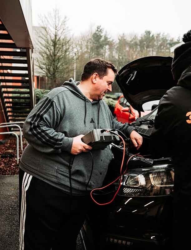 Image of an autolocksmith using a tool on a car.